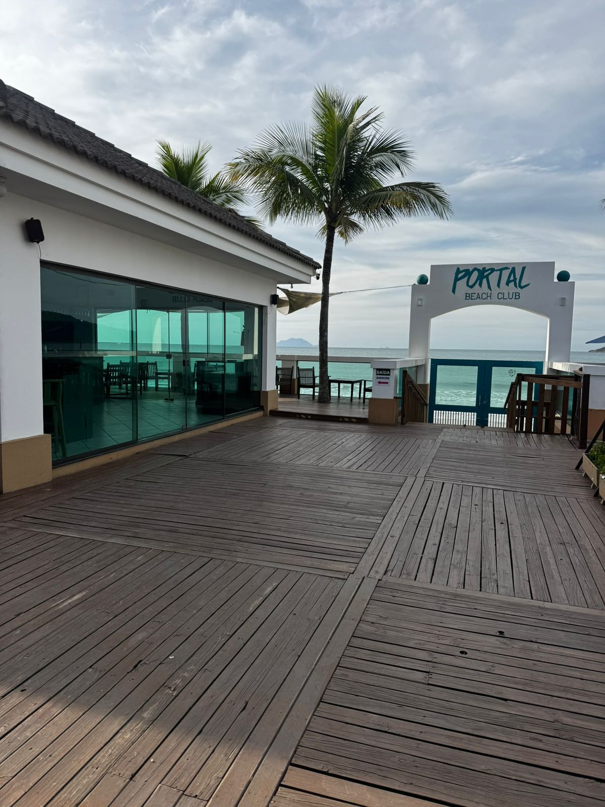 Deck do Portal Beach Club com palmeiras e vista para o mar na Praia dos Ingleses